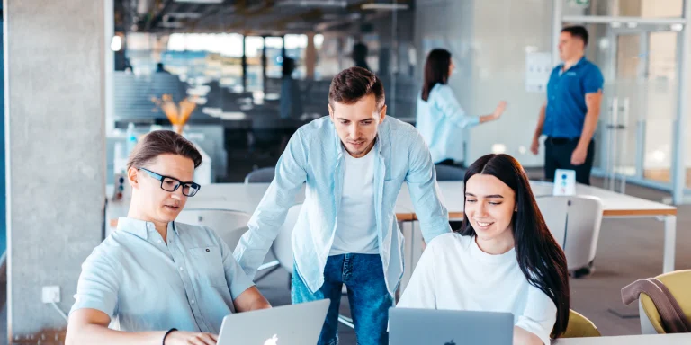 IT team working together around a table with laptops